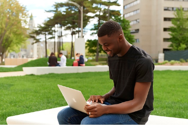 Étudiant sur le campus devant son ordinateur