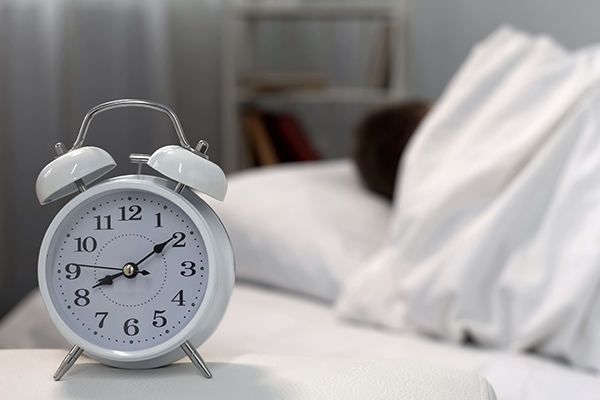 cadran et personne qui dort dans un lit