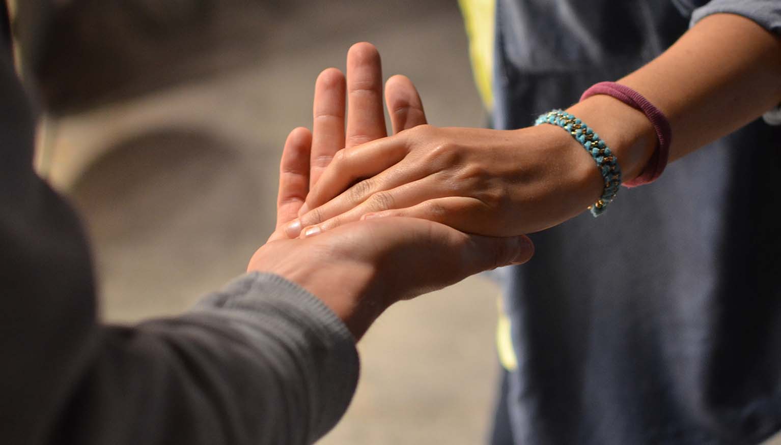 A man and a woman hold hands in sign of mutual aid.