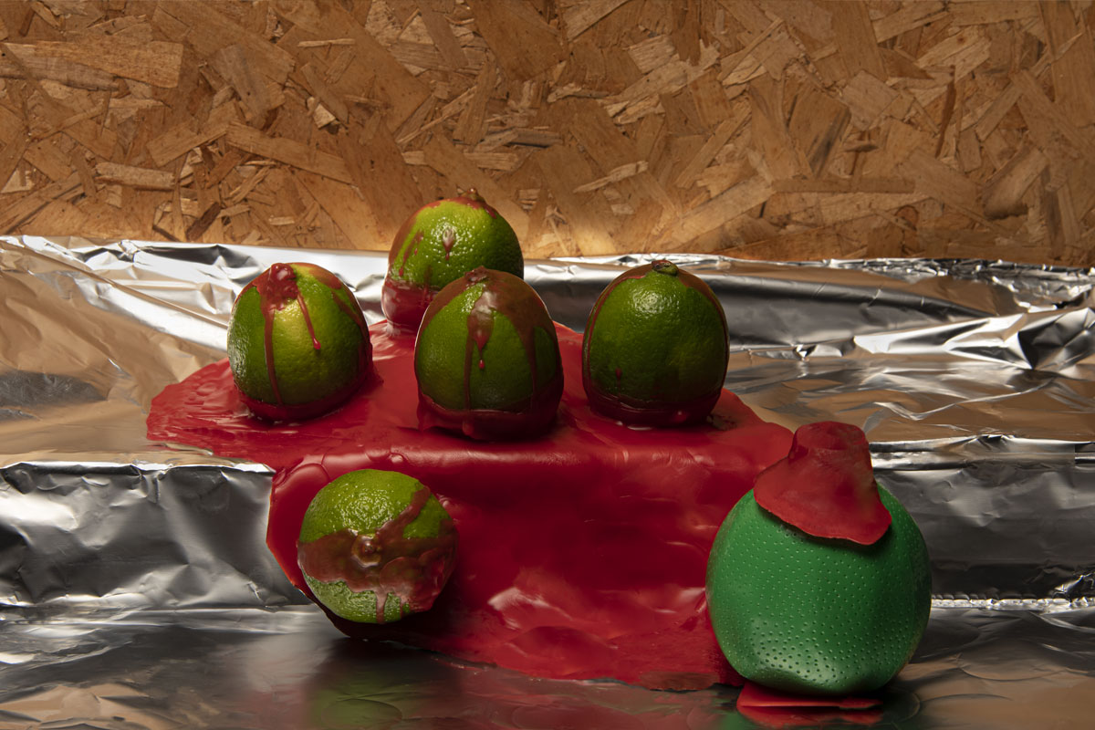 Demi-limes fraîches sur un lit de cire rouge et s'écoulant vers une lime en plastique