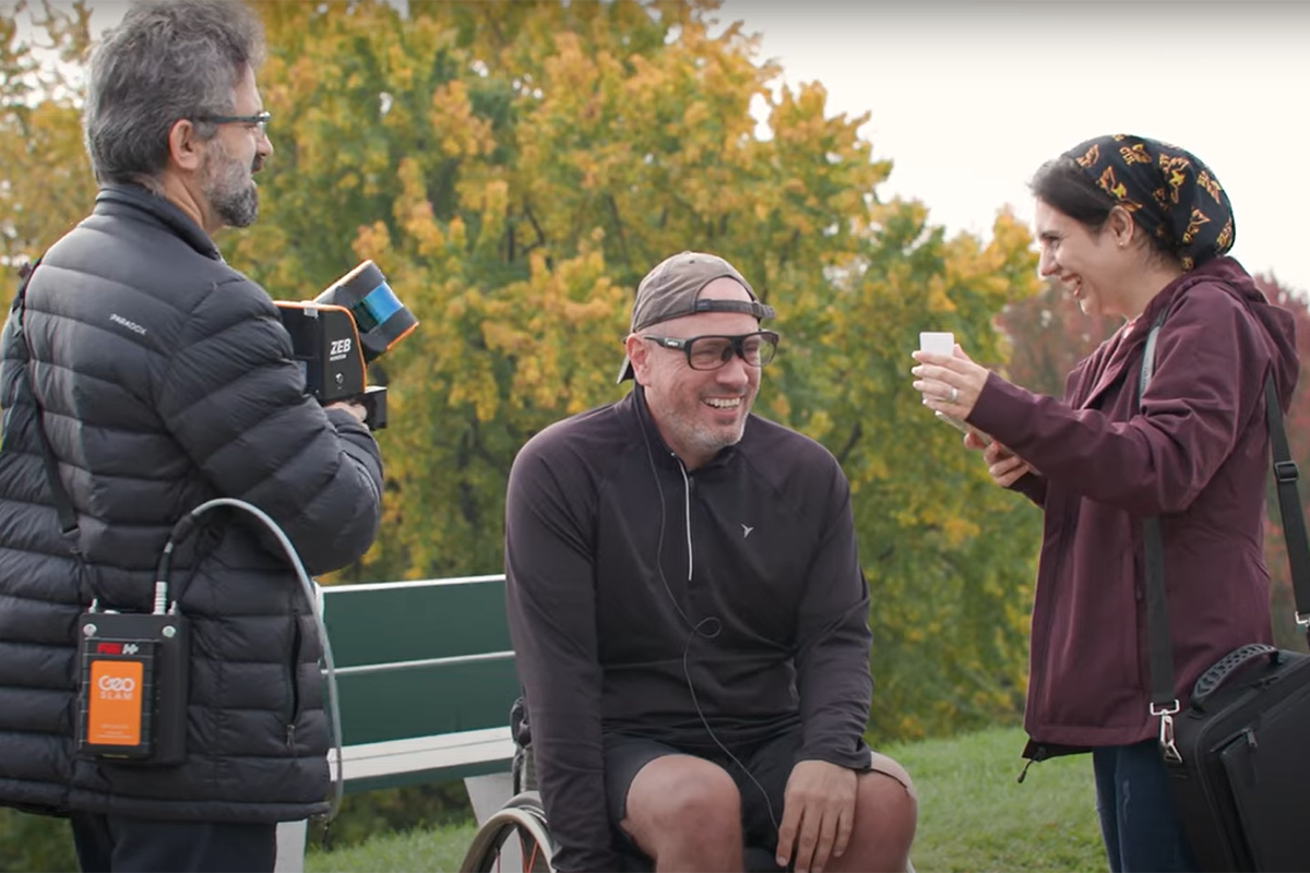 Mir Abolfazl Mostafavi, Mike Prescott et une jeune femme discutent en riant.