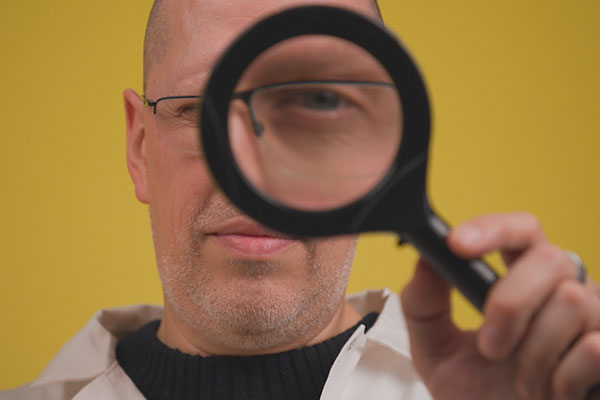 homme tenant une loupe