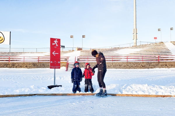 Adulte et enfants sur la patinoire du campus nordique