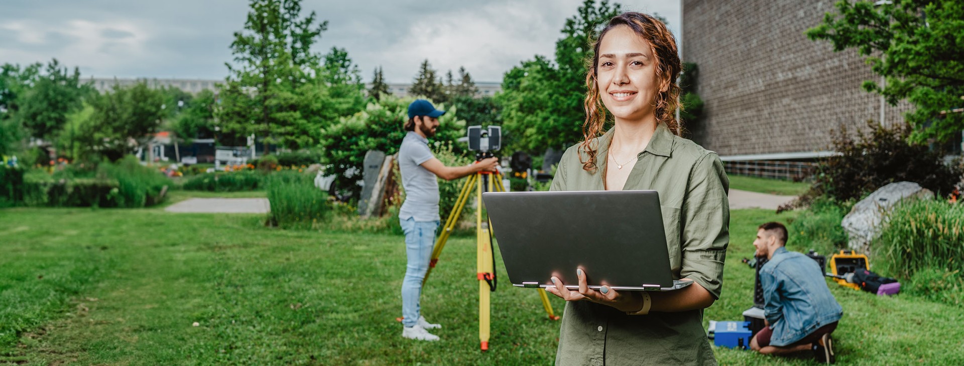 étudiante tenant un ordinateur portable sur le campus de l'Université Laval