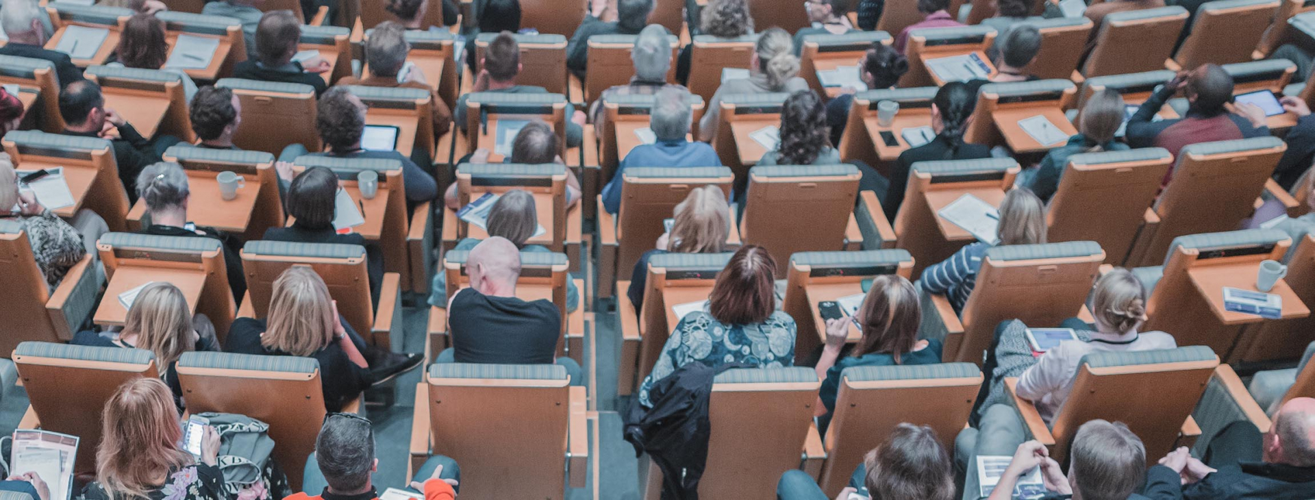 Participants à une conférence assis dans un auditorium.