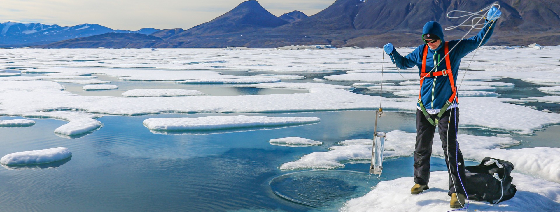 Scientifique sur la glace qui prend un échantillon d'eau