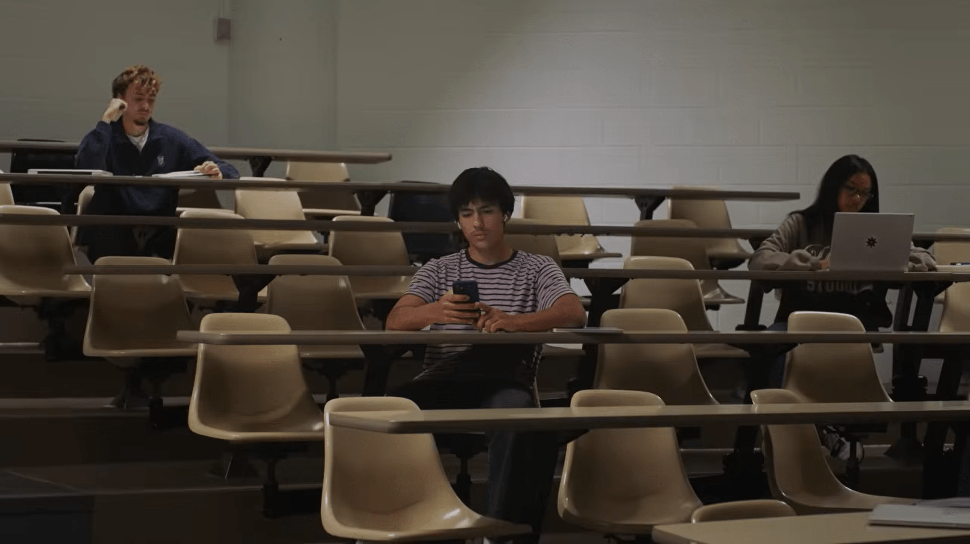 Une personne étudiante écoute une émission à caractère masculiniste sur son cellulaire.