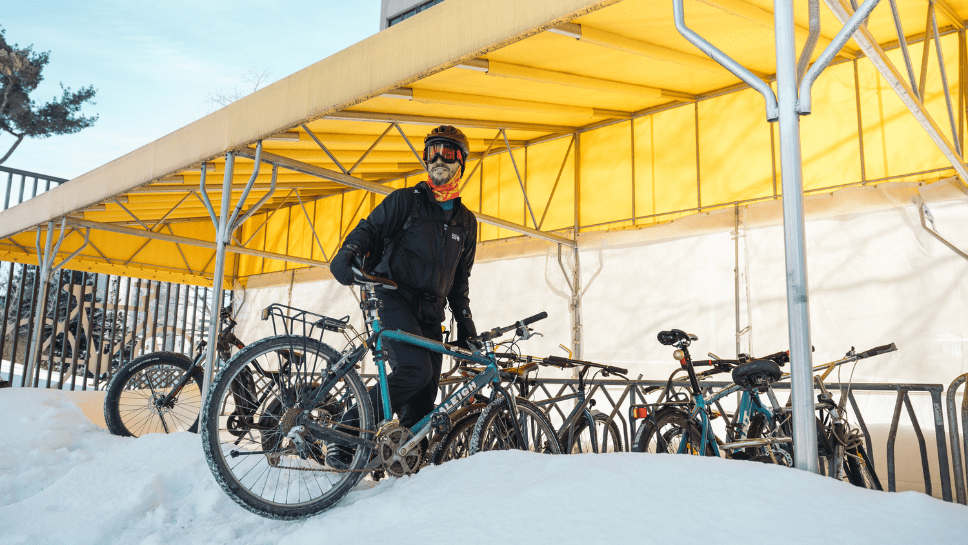 Jeune homme avec un vélo dans la neige