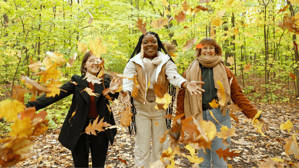 3 personnes avec des feuilles d'automne