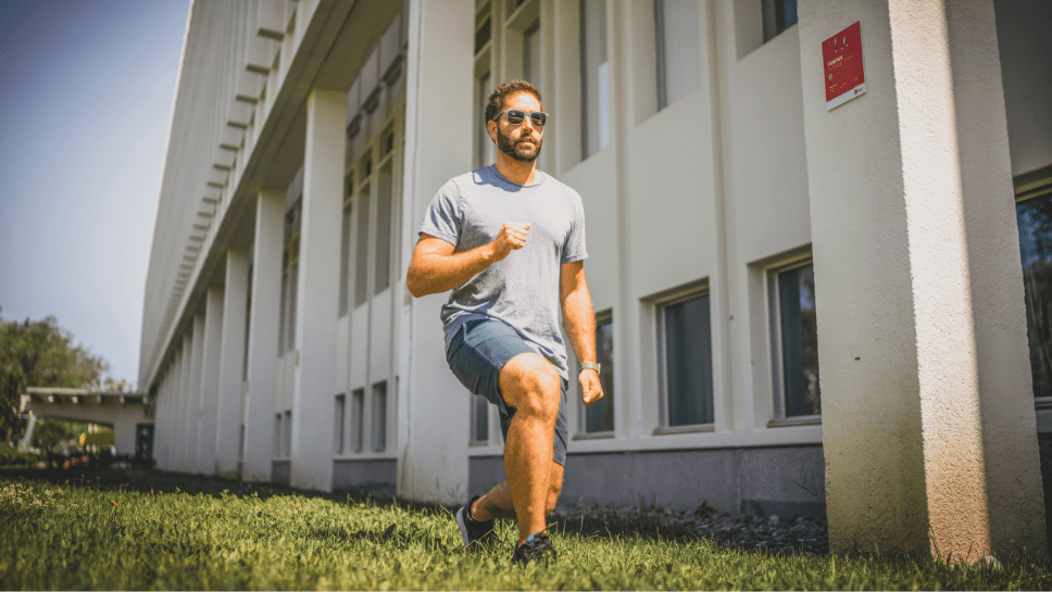 jeune homme faisant des fentes dehors