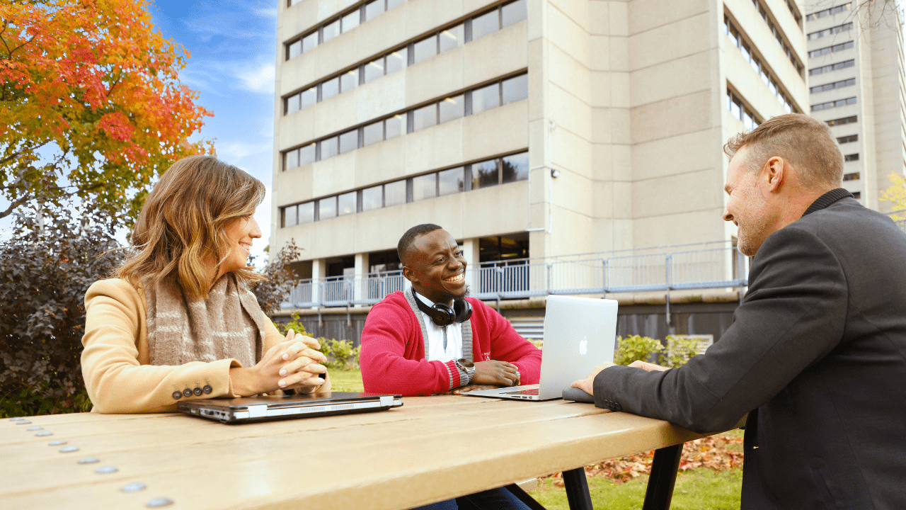 Trois personnes qui discutent dehors