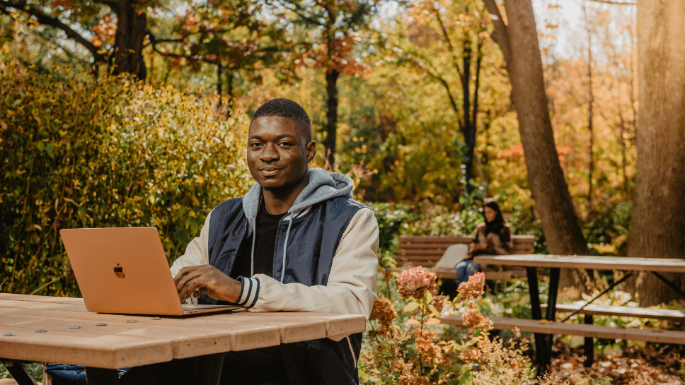 jeune homme à l'extérieur avec ordinateur portable