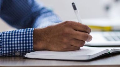 Main écrivant dans un cahier