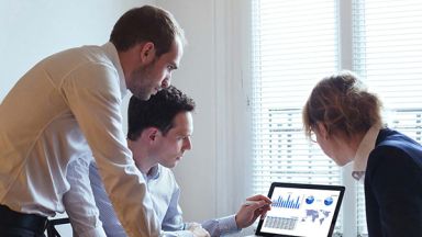 trois personnes devant un ordinateur