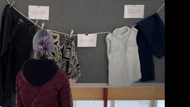 Une personne regarde l'exposition Que portais-tu ?