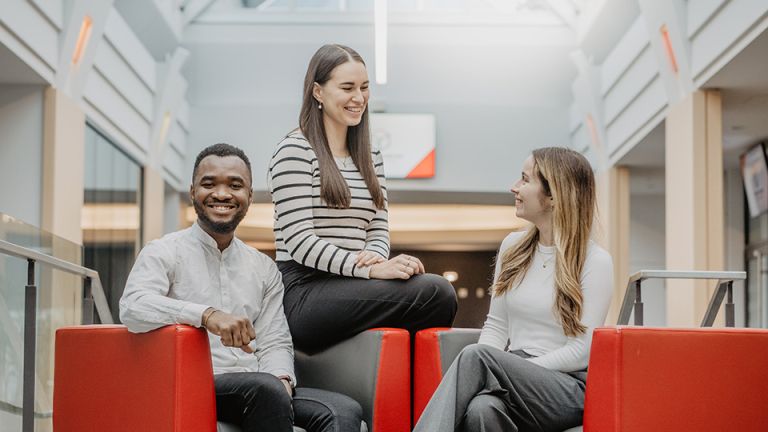 Trois étudiants assis sur des bancs