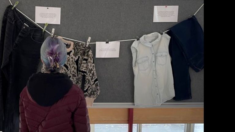 Une personne regarde l'exposition Que portais-tu ?